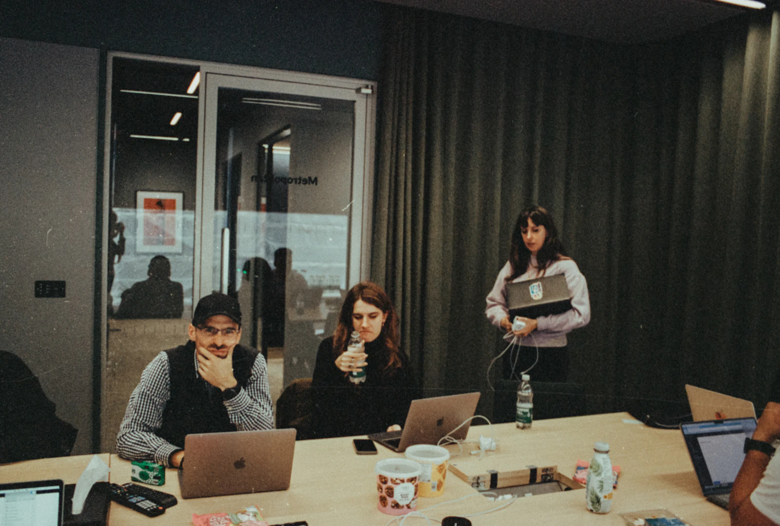 Colleagues gathered around a table with their laptops